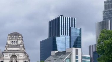 Londra 'nın merkezinde eski ve modern mimarinin aksine, ön planda ağaçlar, yavaş çekim