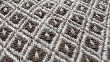 Yinelenen geometrik elmas desenli dokuma kumaş yüzeyinin yakın çekim görüntüsü, yumuşak çekimde doğal renk paleti