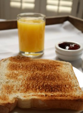 Sabah kahvaltısı. Tahta tepside tost, portakal suyu ve meyve reçeli servis ediliyor. Cotswold kırsal, İngiltere