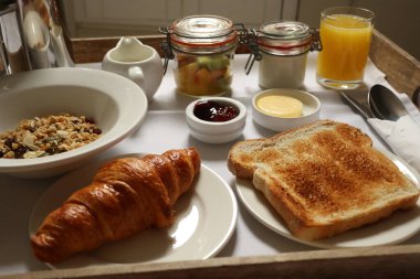 Müsli, kruvasan, tost, meyve, yoğurt, reçel, tereyağı ve portakal suyu içeren Avrupa kahvaltısı. Cotswold kırsal, İngiltere