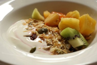 Tahıllı yoğurt, kivi, ananas, kavun, kurutulmuş kızılcık ve kabak çekirdeği. Cotswold kırsal, İngiltere