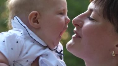Green Park 'ta boş zamanlarını geçirirken annesinin tatlı küçük kızını öpmesi. 4K Ağır çekim