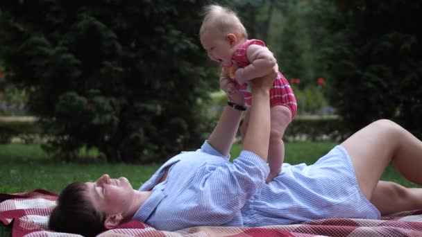 Мама Играет Дочерью Парке Лежат Клетке Мама Поднимает Ребенка Воздух — стоковое видео