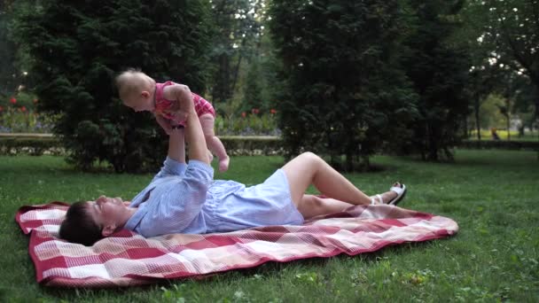 Máma Leží Trávě Parku Vychovává Dítě Vzduchu Pomalá — Stock video