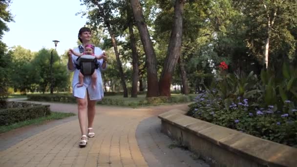 Cámara Movimiento Mamá Sonriendo Camina Con Bebé Parque Una Niña — Vídeos de Stock