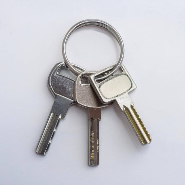 A close-up view of several European house keys attached to a metal ring. The keys feature different shapes and designs, highlighting their unique features and functionality. clipart