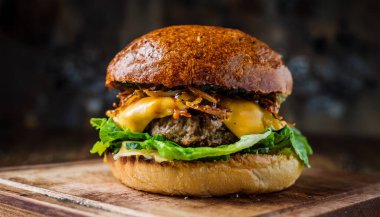 This delicious smash burger features a perfectly seared beef patty with crispy edges, topped with melted cheese, fresh lettuce, and savory caramelized onions. Enjoy the mouthwatering flavors of a classic favorite in every bite. clipart