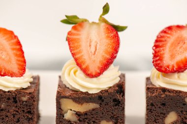 Deliciously rich cake brownie slice with Chantilly cream and fresh strawberry.