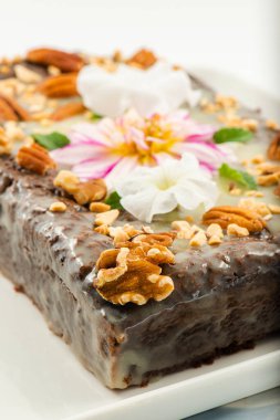 Freshly baked chocolate loaf cake with a variety of crushed nuts.