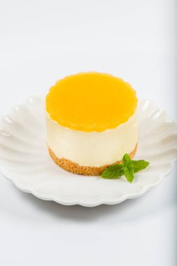Kremalı minyon mango peynirli kek, mango jölesi ve kepekli bisküvi kırıntısı..