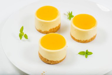 Kremalı minyon mango peynirli kek, mango jölesi ve kepekli bisküvi kırıntısı..