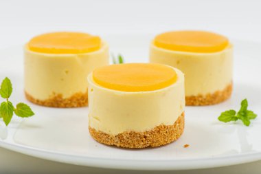 Kremalı minyon mango peynirli kek, mango jölesi ve kepekli bisküvi kırıntısı..