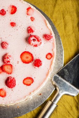 Homemade mixed berry cheesecake with a biscuit crumb and fruit puree.