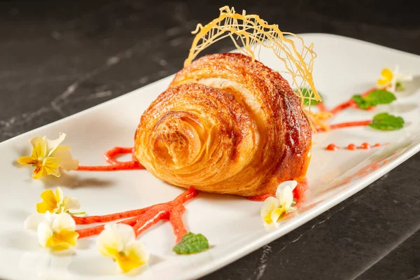 Close-up of crispy, flaky, and delicious butter croissant coated in cinnamon sugar.