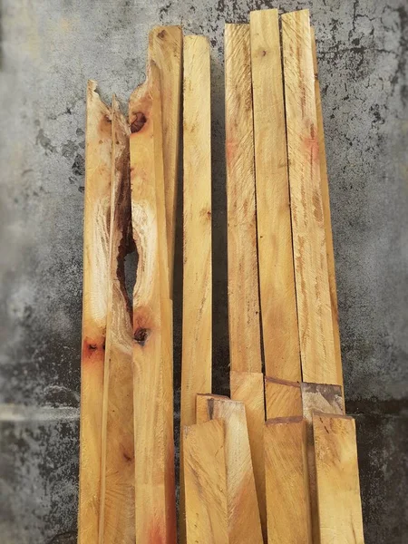 Yellow color pieces of wood sticks to the wall. Pieces of wood can be used in many different ways, such as building structures, creating furniture, or making decorative objects