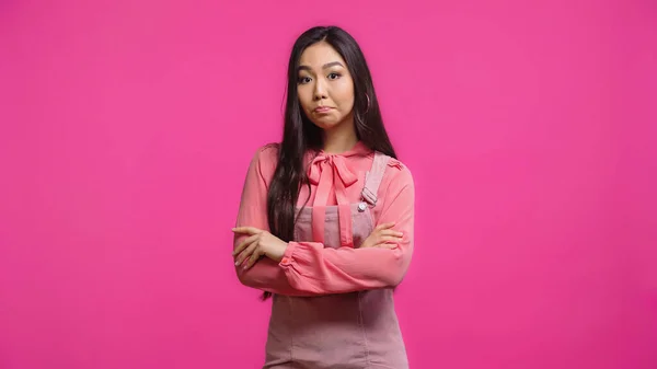被冒犯的亚洲女人站在那里 双臂交叉 与粉色隔离 — 图库照片
