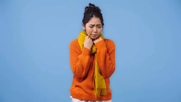 Enfermo asiático mujer en naranja suéter y bufanda sensación malestar aislado en azul — Stock Photo