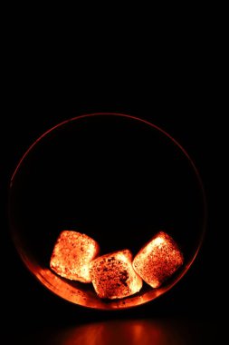 Gürültü, etki ve tahıl detaylarıyla zenginleşen parlak kömürleri karanlıkta mistik bir atmosfer yaratır. Canlı bir ısı ve derinlik hissi görüntüyü sarar