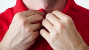 Eller polo tişörtünü ilikliyor. Renkli bir polonun yakasının düğmesini iliklemeye çok yakınsın. Poloshirt 'ini ayarlayan adam. Düğmeli stil, üniformalar ve resmi elbiseler. Rahatsız hissediyorum..