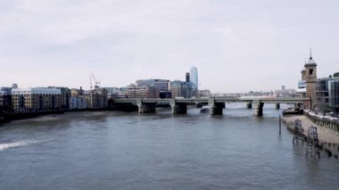 Londra, İngiltere - 13 04 2024: Thames yukarıdan görüldü. Güneşli bir günde Londra. Feribot ve tekneler nehri geçiyor. Uzakta uzun gökdelenler var. Turizm, iş, modern şehirler. 4k ağır çekim videosu.