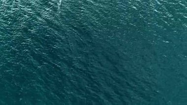 Adam su üzerinde hidrofolyo sörf tahtasıyla uçuyor. Uzak mesafedeki sporcu gün batımında büyük bir gölde folyo sörf tahtasına biner. İnsan ve su, havadan 4k atış, doğayla temas, ekstrem sporlar, özgürlük.