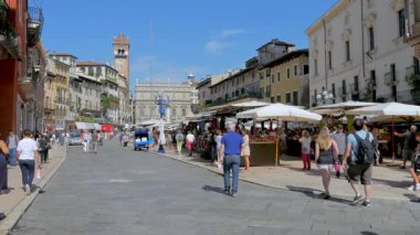 Verona, İtalya - 07 05 2018: Piazza Erbe. Verona 'nın ana meydanı, geleneksel pazarı ile ünlüdür. Bir yaz günü şehri ziyaret eden turistler.