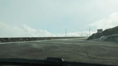 Rüzgâr bataklığı yollara sürüklüyor. Dağdan büyük bir katı kar kütlesi iner. Sabit bir arabanın içinde kum ve kar yığını görünüyor. Kar fırtınası.