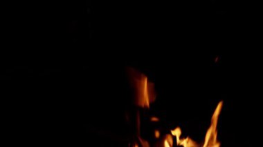 Yanan odun, alevler, şenlik ateşi, karanlıkta ateş. Cehennem, sıcak ve yakıcı. 4k 50fps, el kamerasında kırılan odunların kırmızı ve kırmızı renkte yanıp sönen görüntüsü..