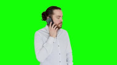 Beyaz gömlekli bir ofis görevlisine telefon geliyor. Uzun saçlı, sakallı ve çörekli adam ofiste akıllı telefonunu kullanıyor. Yeşil Ekran.