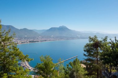 Alanya, Türkiye - 3 Kasım 2022. Güneşli bir günde Alanya kalesinden şehir merkezindeki deniz koyuna ve Taurus dağlarına manzara