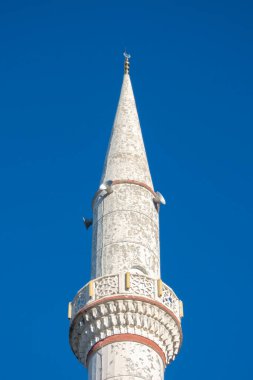Alanya, Türkiye - 4 Ocak 2023. Fatih Sultan Mehmet Camii 'nin minaresi mavi gökyüzüne karşı zarif bir şekilde yükseliyor.
