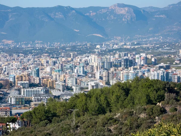 Alanya, Türkiye - 4 Ocak 2023. Arka planda ağaçlar ve dağlar olan Mahmutlar bölgesinin manzarası. Şehrin mimarisinin işlevsel estetiği..