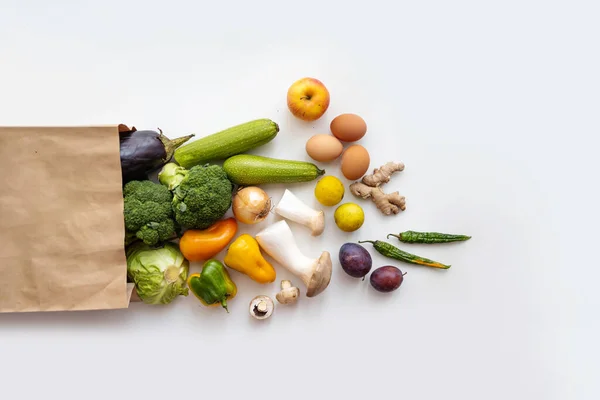 Healthy food delivery background. Healthy vegan vegetarian food in paper bag vegetables and fruits on white, copy space, banner. Supermarket shopping and pure vegan food concept.