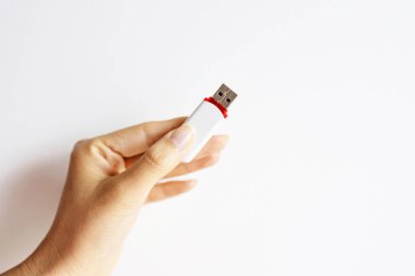 Beyaz bir arka planda izole edilmiş bir kalem diskini gösteren tanınmayan bir kadının el resmi..