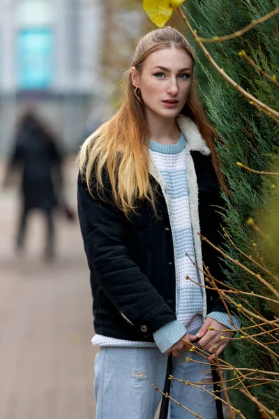 身着牛仔裤外套 留着雀斑和长发的年轻漂亮红头发女子的近照 在欧洲城市的街道上摆姿势 — 图库照片