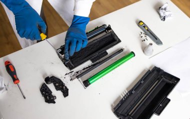 Lazer toner kartuşunu tamir eden eller. işçi lazer yazıcısı çalışma tezgahında.