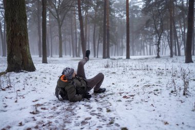 Genç modern insan kaydı ve kışın bir huş ağacı koru üzerine bir yürüyüş sırasında dengesini kaybetti. Atlama ve kar düşmeden önce ellerini sallayarak süre donuk çerçeve.