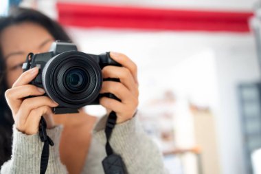 Genç ve mutlu fotoğrafçı evinde bir DSR kamera tutuyor. Kadın fotoğrafçı masasında çalışırken neşeyle gülümsüyor. Yeni bir proje üzerinde çalışan yaratıcı kadın serbest yazar..