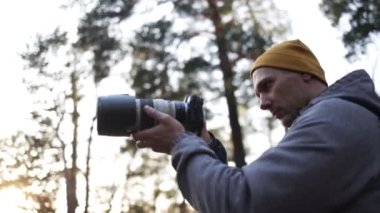 Genç profesyonel fotoğrafçı ormanda fotoğraf çekiyor..
