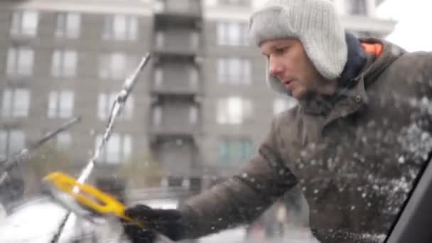 Genç Adam Kış Günü Arabanın Camından Kar Temizliyor — Stok video