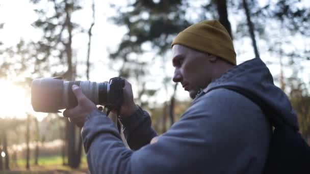 森の中で写真を撮る若いプロの写真家 — ストック動画