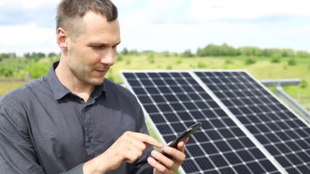 Man Holds Smartphone Solar Panels Plot House — Αρχείο Βίντεο