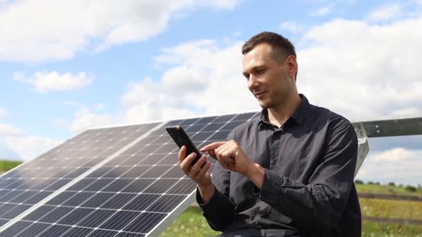 Man Holds Smartphone Solar Panels Plot House — Vídeo de Stock