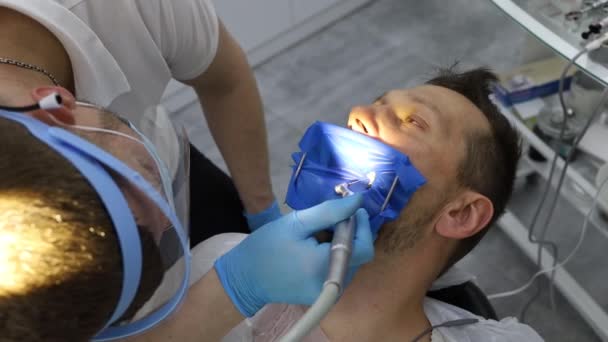 Чоловічий Стоматолог Процесі Буріння Отвору Зубі Чоловіка Лежить Горизонтально Кріслі — стокове відео