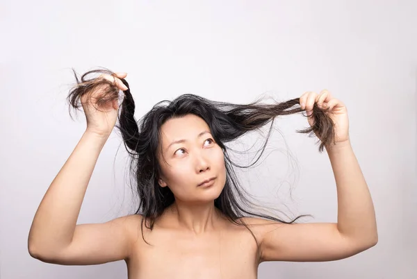 Asian woman have damaged and broken hair, loss hair, dry problem concept.