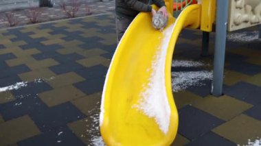 A funny Easter rabbit going down a yellow slide.