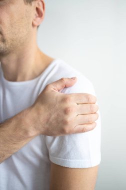 A middle-aged man has shoulder pain on white background. 