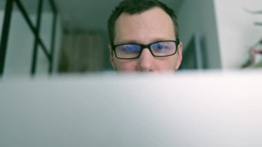 İş iletişimi ya da e-posta bildirimi için okuma gözlüklü ve laptop ekranlı bir adam. Web tasarım işçisi, blog yöneticisi ve seo ağ çalışanı veya bilgisayardan analiz raporları