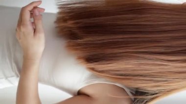 Closeup on a young woman combing her hair