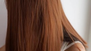 Closeup on a young woman combing her hair